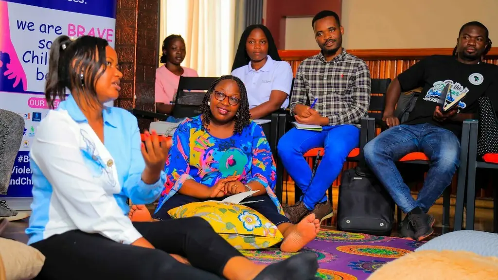 Diverse group seated in room, engaging in discussion or meeting.