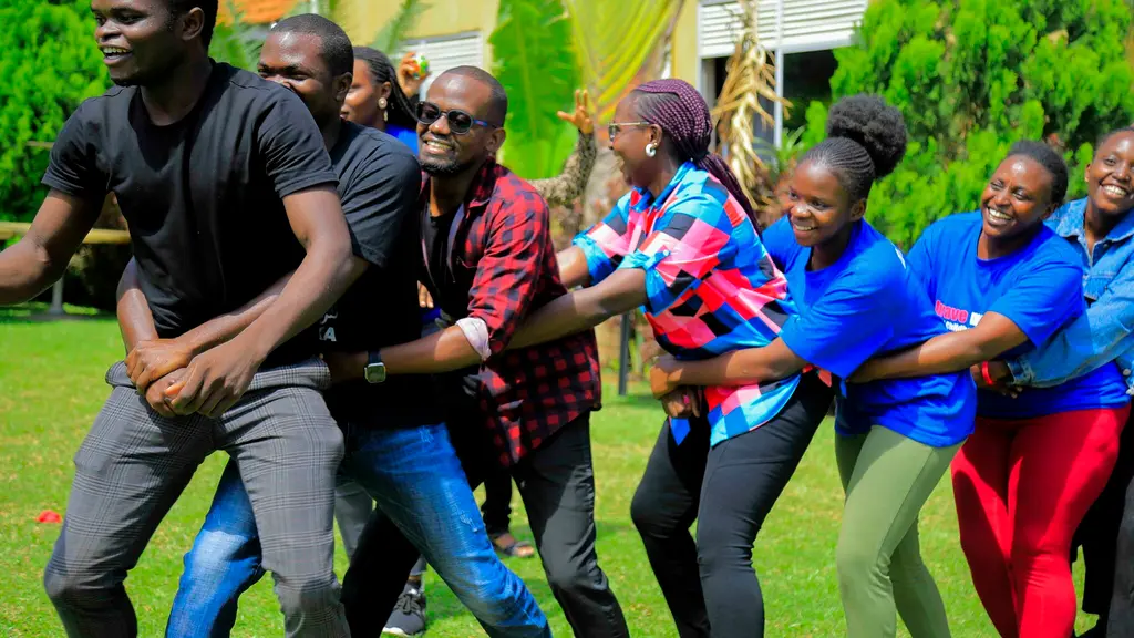 Group of adults in colourful clothing standing together outdoors in a garden setting.