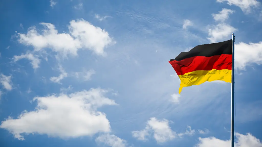 ドイツ国旗。赤、黄、黒のバンドが空に映えている。青空と白い雲が広がっている。