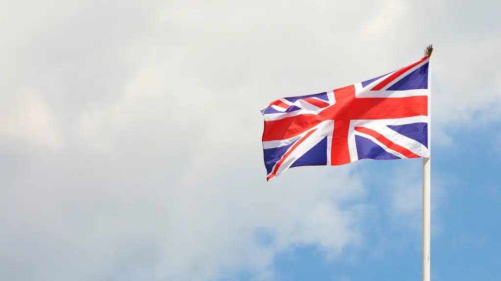 国旗イギリスの赤と青の旗が風に翻っている。白い雲のある青い空を背景にしている。