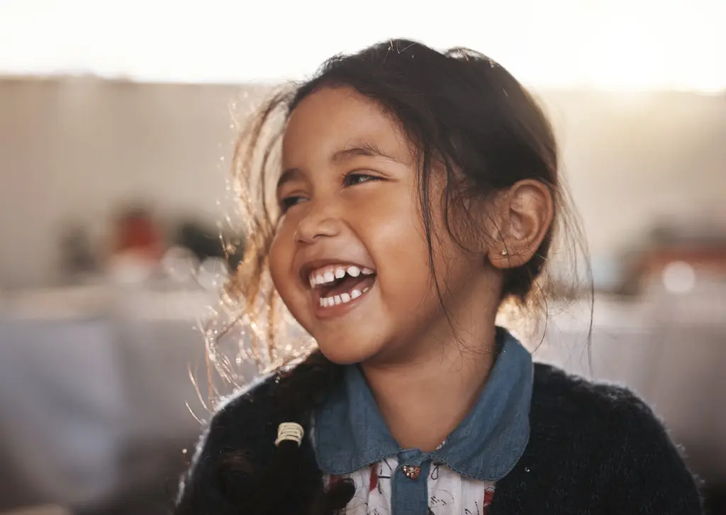 Smiling girl with windblown hair looking cheerful.